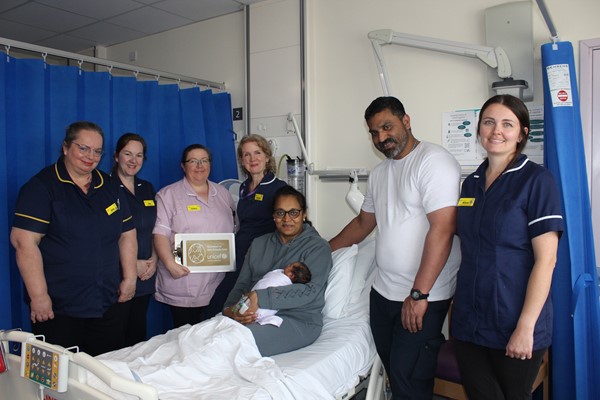 Infant feeding team and managers with parents and new baby